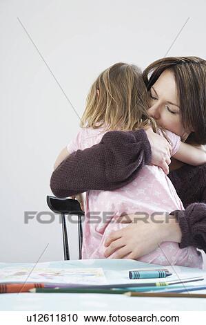 Stock Image - Mother hugging daughter (3-4). Fotosearch