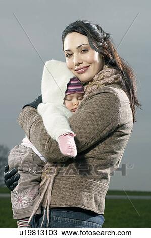 Stock Image - Mother hugging sleeping baby. Fotosearch