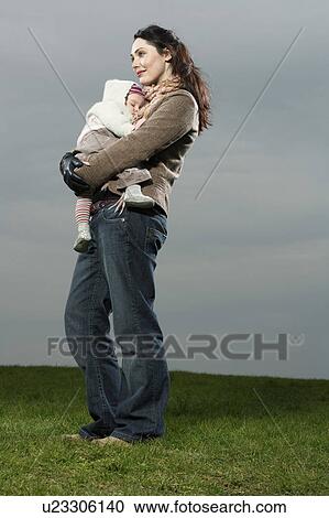Mother in park, holding sleeping baby, View Large Photo Image Stock Image - Mother in park, holding sleeping baby,. Fotosearch