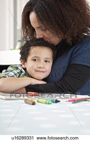 Stock Image - Mother kissing son (5-6). Fotosearch