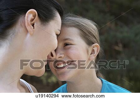 Picture - Mother looking into daughters eyes, smiling, close-up. Fotosearch