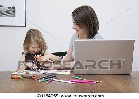 Mother playing with daughter (3-4), open laptop on table View Large Photo Image Stock Photo - Mother playing with daughter (3-4), open laptop on table. Fotosearch