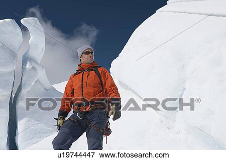 Stock Photo - Mountain climber in front of ice formation. Fotosearch