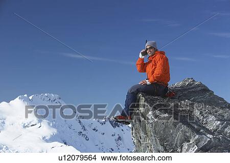 Mountain climber using walkie-talkie on mountain peak View Large Photo Image Picture - Mountain climber using walkie-talkie on mountain peak. Fotosearch