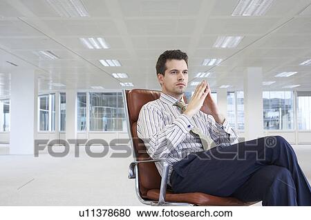 Office worker sitting in swivel chair in empty office space View Large Photo Image Stock Image - Office worker sitting in swivel chair in empty office space. Fotosearch