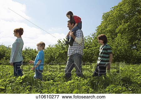 Stock Photo - Parents and children (5-9) in a row in strawberry field. Fotosearch