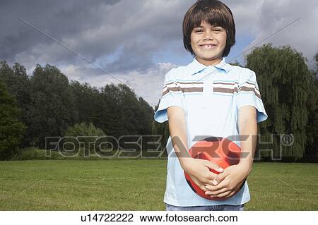 Portrait of boy (7-9) in meadow with football View Large Photo Image Stock Image - Portrait of boy (7-9) in meadow with football. Fotosearch