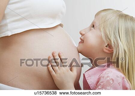 Portrait of girl (7-9) hugging pregnant mother's belly View Large Photo Image Stock Photo - Portrait of girl (7-9) hugging pregnant mother's belly. Fotosearch