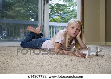 Portrait of girl (7-9) lying on carpet with book, hand on chin View Large Photo Image Stock Image - Portrait of girl (7-9) lying on carpet with book, hand on chin. Fotosearch