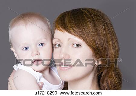 Stock Image - Portrait of mother with baby boy (1-2), studio shot. Fotosearch