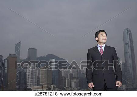 Stock Photo - Portrait of young business man, office building in background. Fotosearch