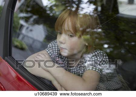Stock Photo - Pre-teen girl looking through car window and contemplating. Fotosearch