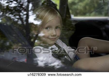 Stock Photo - Pre-teen girl looking through car window. Fotosearch