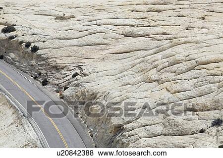 Stock Photo - Road through rock formation in desert, elevated view. Fotosearch