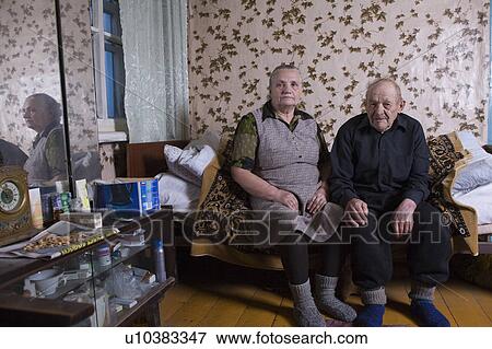 Stock Photo - Russia, senior couple sitting on bed. Fotosearch