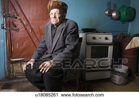 Russia, senior man sitting in kitchen View Large Photo Image Stock Image - Russia, senior man sitting in kitchen. Fotosearch