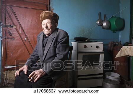 Russia, senior man sitting in kitchen View Large Photo Image Stock Photo - Russia, senior man sitting in kitchen. Fotosearch