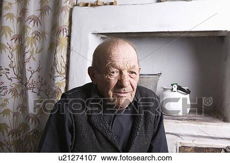 Stock Photo - Russia, senior man sitting in kitchen. Fotosearch