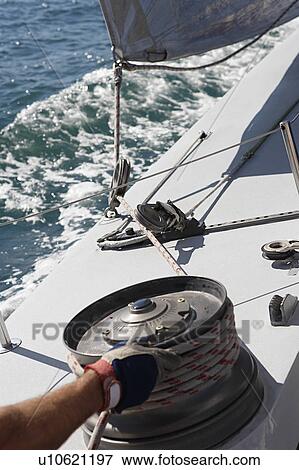 Sailor adjusting rope on boat, close up of hand View Large Photo Image Stock Photo - Sailor adjusting rope on boat, close up of hand. Fotosearch