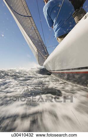 Stock Image - Sailor on yacht in ocean. Fotosearch