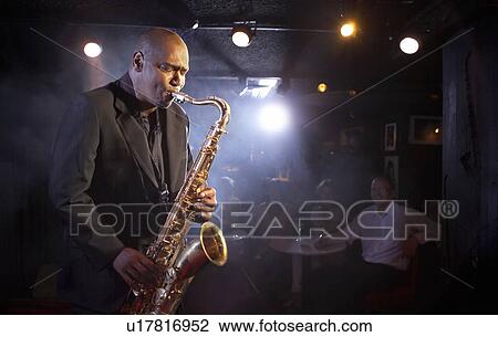 Stock Image - Saxophone player on stage, portrait. Fotosearch