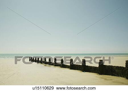 Stock Photo - Sea defenses stretch out to low tide. Fotosearch