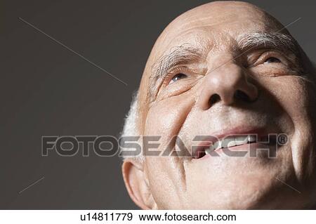 Senior man in studio, close up, low angle view View Large Photo Image Stock Photo - Senior man in studio, close up, low angle view. Fotosearch