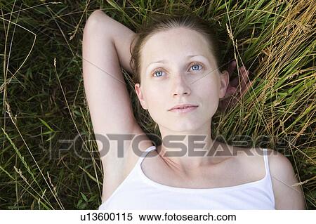 Serene young woman daydreaming on grass View Large Photo Image Stock Photography - Serene young woman daydreaming on grass. Fotosearch