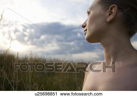 Stock Image - Serene young woman in meadow. Fotosearch