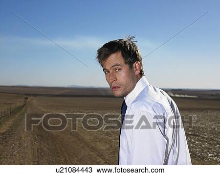 Serious businessman looking over his shoulder View Large Photo Image Stock Image - Serious businessman looking over his shoulder. Fotosearch