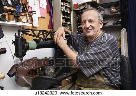 Stock Photo - Shoemaker Repairing Boot in Shoe Shop. Fotosearch