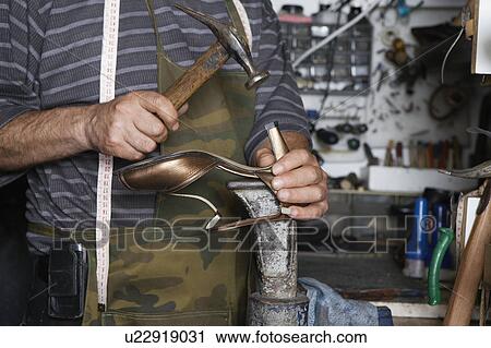 Stock Image - Shoemaker Repairing High Heel Shoe. Fotosearch