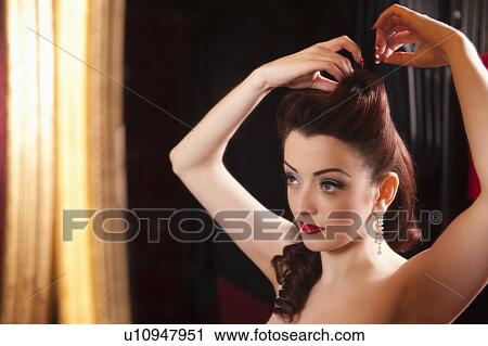 Stock Image - Showgirl doing her hair. Fotosearch