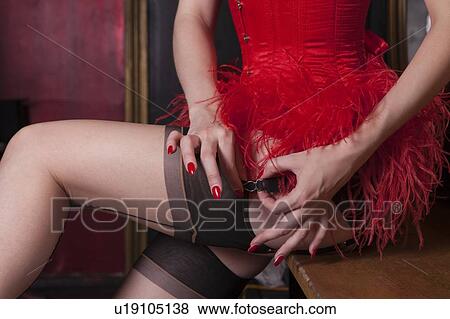 Stock Photo - Showgirl putting on suspenders. Fotosearch