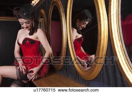 Stock Photography - Showgirl putting on suspenders. Fotosearch