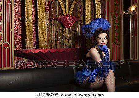 Stock Photography - Showgirl sitting on couch. Fotosearch