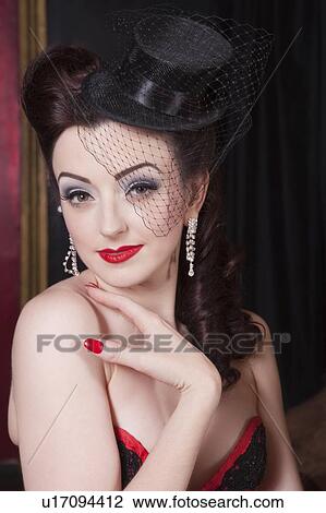 Stock Image - Showgirl with miniature hat, portrait. Fotosearch