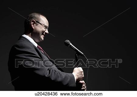 Smiling man in full suit holding microphone, side view View Large Photo Image Stock Photograph - Smiling man in full suit holding microphone, side view. Fotosearch