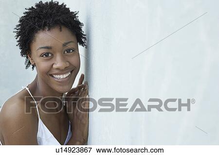 Smiling woman leaning against wall, portrait View Large Photo Image Stock Photo - Smiling woman leaning against wall, portrait. Fotosearch