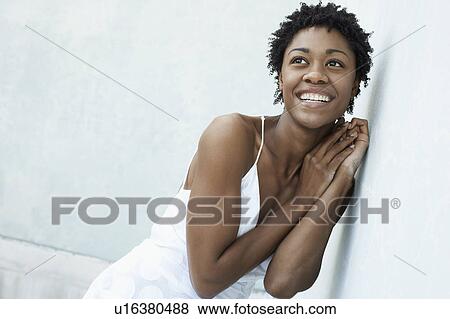 Smiling woman leaning against wall, portrait View Large Photo Image Stock Photo - Smiling woman leaning against wall, portrait. Fotosearch