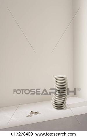 Stock Photo - Spoons next to stack of plates on table. Fotosearch