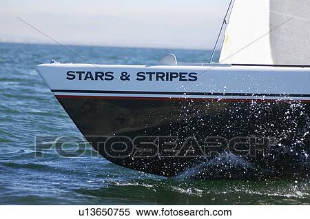 Stock Photography - Stars and stripes sailboat on ocean. Fotosearch