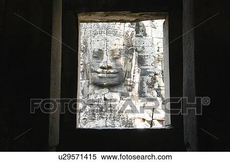 Stock Photography - Stone Face Sculpture Seen Through Window of Ruins. Fotosearch