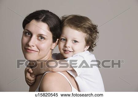Stock Photography - Studio portrait of boy embracing mother. Fotosearch
