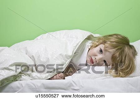 Studio shot of girl (5-6) lying in bed View Large Photo Image Stock Photo - Studio shot of girl (5-6) lying in bed. Fotosearch