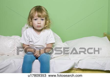 Studio shot of girl (5-6) sitting on bed View Large Photo Image Stock Image - Studio shot of girl (5-6) sitting on bed. Fotosearch