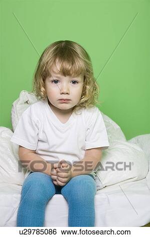 Studio shot of girl (5-6) sitting on bed View Large Photo Image Stock Photograph - Studio shot of girl (5-6) sitting on bed. Fotosearch