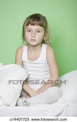 Studio shot of girl (7-9) sitting on bed View Large Photo Image Stock Image - Studio shot of girl (7-9) sitting on bed. Fotosearch