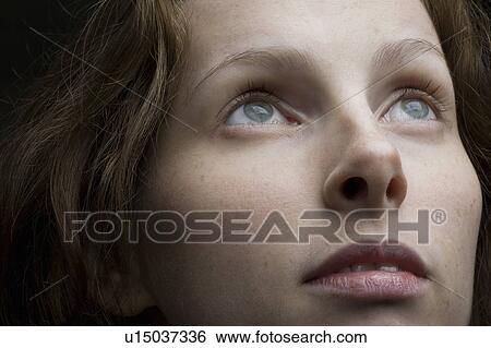 Studio shot of mid-adult woman looking up View Large Photo Image Stock Photograph - Studio shot of mid-adult woman looking up. Fotosearch