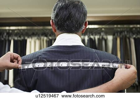 Stock Photo - Tailor measuring business man for suit, close up. Fotosearch